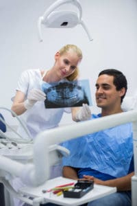 מטופל מקבל טיפול אצל רופאת שיניים מומחית