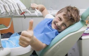 ילד מחייך באמצע טיפול שיניים