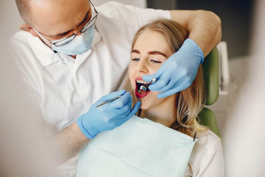רופא שיניים בודק שיניים למטופלת